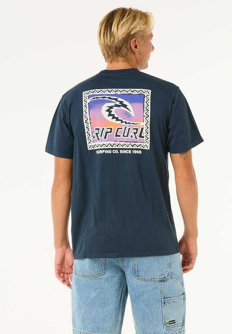 Navy blue cotton t-shirt featuring a colorful retro graphic on the back with the text "RIP CURL" surrounded by a zigzag border.