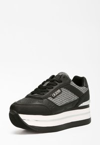 Scarpa da ginnastica nera con esterno in pelle liscia e tessuto nero e argento texturizzato. Presenta una suola platform bianca spessa e dettagli con logo.