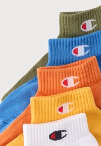 Βαμβακερές κάλτσες μάλλινες σε πράσινο, μπλε, πορτοκαλί, κίτρινο και λευκό, με ριμπ ύφανση και λογότυπο στη μανσέτα κάθε κάλτσας.