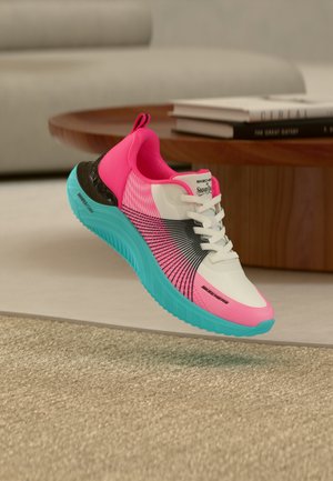 Rózsaszín, fehér és fekete tornacipő élénk kék talppal, fehér fűzőkkel és "Skechers x Snoop Dogg" logóval, lebegve egy bézs színű szőnyeg felett beltéren.