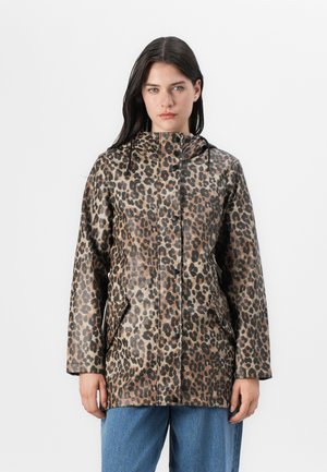Model in een waterdichte jas met luipaardprint, voorzien van een capuchon en zakken, tegen een plain witte achtergrond. Natuurlijke gezichtsuitdrukking.
