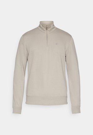 Béžová mikina so štvrťzipsom, vyrobená z mäkkej látky, s rebrovaným golierom, manžetami a lemom, s malým logom na hrudi.