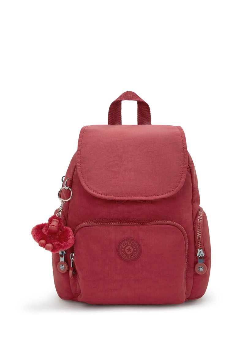 Mochila de nylon roja con tapa, bolsillo frontal con cremallera, bolsillos laterales, detalle de logo circular y un llavero de mono desmontable.