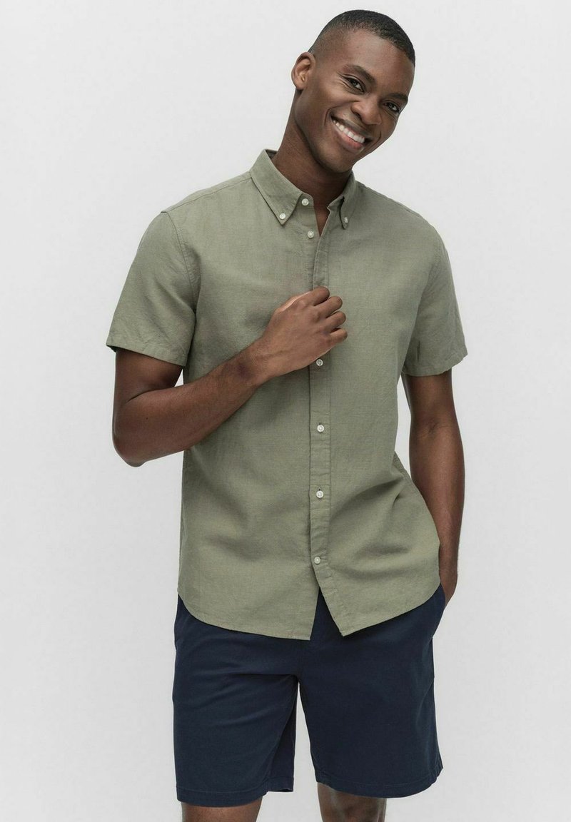 Korte mouwen overhemd met knopen in licht olijfgroen, gemaakt van linnen, met een relaxed fit, gecombineerd met marineblauwe shorts. Soepele textuur en klassiek ontwerp.