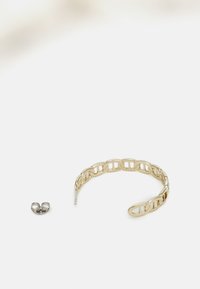 Guld metal kædearmbånd med ovale led og et lille sølvøre-cuff. Glat tekstur og poleret finish.
