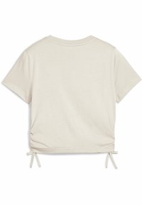Camiseta de manga corta en color beige con detalle fruncido en los laterales y lazos, hecha de una tela suave con una textura lisa y escote redondo.