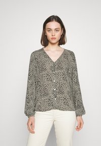 Langermet bluse med V-hals i olivengrønn med svarte leopardflekker, med knapplukking foran og mansjetter på ermene. Glatt, lett stoff.