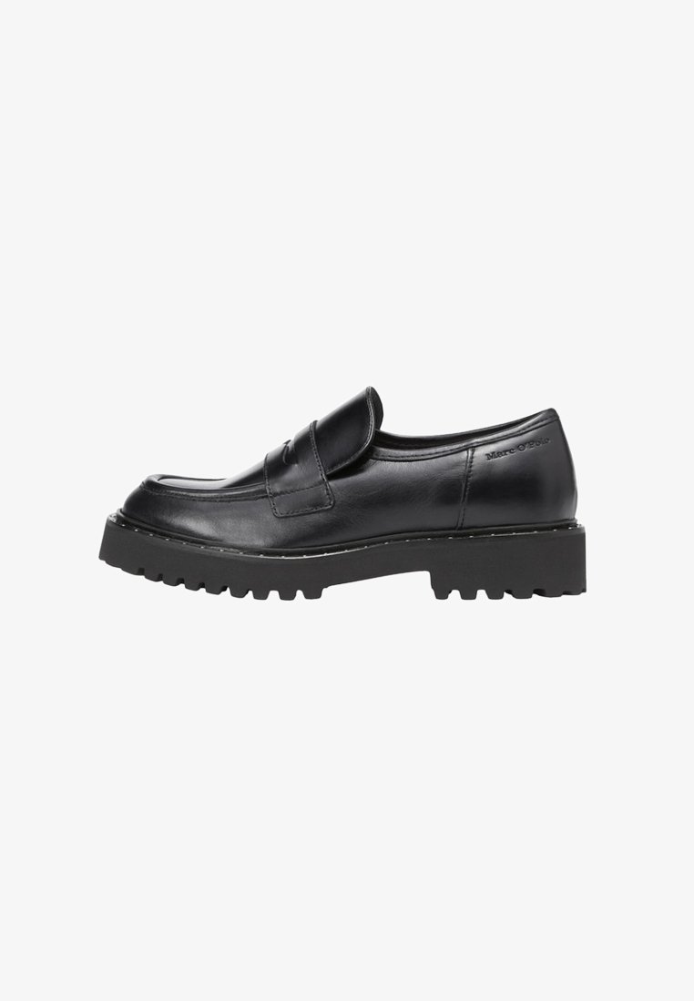Mocassin en cuir noir avec une semelle épaisse crantée, style slip-on et une bride à l’avant, marque Marc O’Polo près du talon.