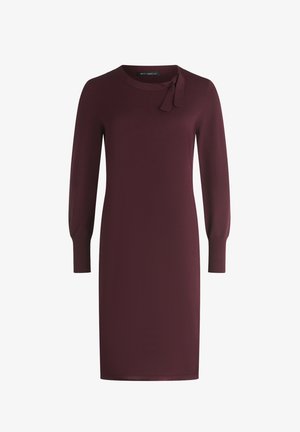 Robe bordeaux avec un col rond, des manches longues et un détail de nœud au niveau du col. Tissu lisse avec une silhouette ajustée.