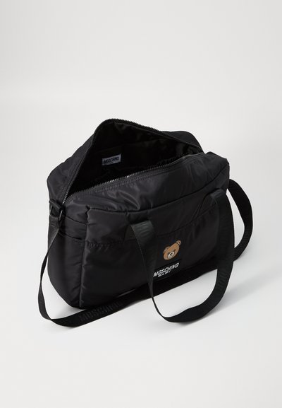 Borsa nera in nylon con chiusura a zip, con logo di un orso bruno e manici in tessuto nero. L'interno è liscio e non foderato.
