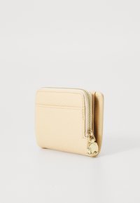 Cardholder bej din piele, cu o suprafață texturată, închidere cu fermoar și accesorii de culoare aurie. Dispune de un compartiment exterior și are o formă rectangulară compactă.