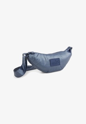 Sac banane rembourré bleu marine de la marque Puma avec sangle ajustable et écusson logo sur fond blanc.