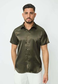 Chemise satin olive à manches courtes avec un devant boutonné, un col et un ourlet arrondi. Texture lisse et léger éclat.