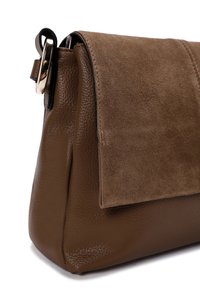 Sac à main en cuir brun et en daim avec une surface texturée, fermeture à rabat et accents en métal doré. Design compact et structuré.