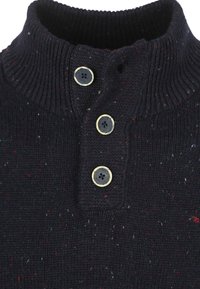 Navy gebreide trui met een hoge kraag, voorzien van drie zwarte knopen met gouden randen en multikleuren spikkels door de stof.