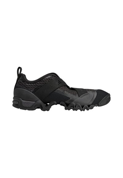 Black athletic shoe with a flexible, textured upper and rubber sole. Features mesh panels, contrasting accents, and a pull tab at the heel.