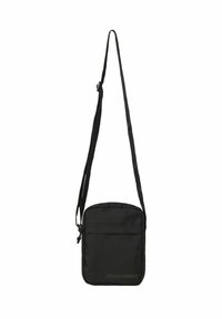 Sorte crossbody taske lavet af slidstærkt stof, med lynlåslukning, justerbar rem og en frontlomme med præget logo-detalje.