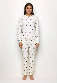 Completo pigiama bianco con pois neri e piccoli disegni di panda. Maglietta a maniche lunghe e pantaloni lunghi con polsini elasticizzati. Tessuto morbido e leggero.