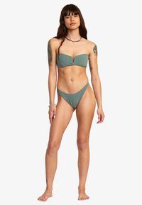 Bikini-set i dämpad grön färg med en tubtopp med V-urringning och matchande lågt skurna trosor, tillverkade av texturerad tyg.