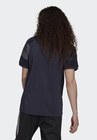 Marineblaue Baumwoll-T-Shirt mit kurzen Ärmeln und Rundhalsausschnitt, mit einem strukturierten Muster im Schulterbereich.