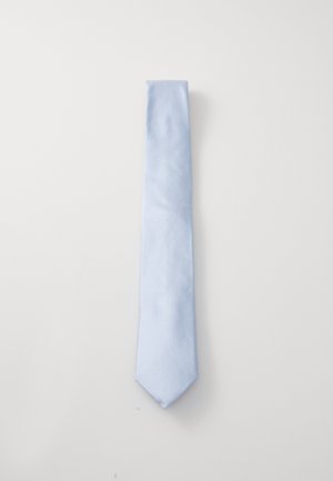 Heledad sinine lips, mis on valmistatud sileda kangaga ja millel on õrn diagonaalne triibumuster. Omab teravat otsa ja klassikalist kitsast kuju.