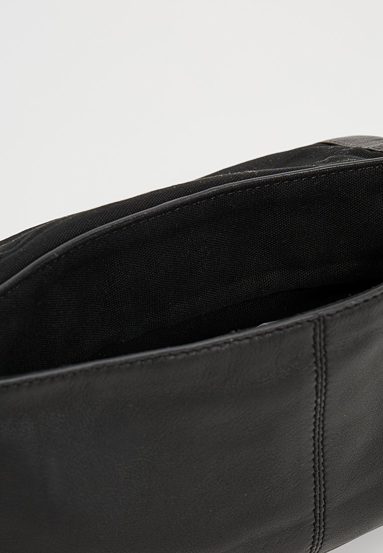 Schwarze Lederhandtasche mit glattem Äußeren und sichtbaren Nähten. Innenausstattung mit schwarzem Stofffutter. Offenes Design.