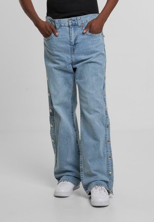 Jeans in denim azzurro chiaro con gambe larghe, dotati di chiusure a pressione laterali, un classico design a cinque tasche e una vita in contrasto.