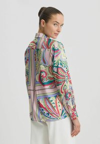 Multicolor zijden blouse met ingewikkelde paisley- en bloemmotieven. Lange mouwen, met kraag design en een relaxte pasvorm met knoopdetails.