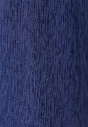 Tessuto blu scuro con una densa texture verticale arricciata che crea un motivo di superficie increspata.