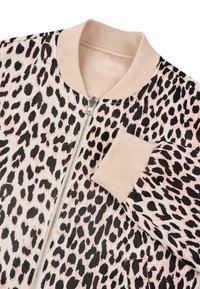 Bomber bunda s leopardím vzorom na ružovom podklade, čiernymi škvrnami, texturovanými ribbed manžetami a predným zipsom. Mäkký materiál s hladkým povrchom.