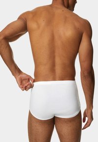 Boxer briefs bianchi in cotone, design aderente con una texture liscia, vita elastica e taglio basso, mostrano solo la vista posteriore.