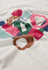 T-shirt bianco con motivi astratti di pennellate multicolori in rosa, verde, blu e marrone. Tessuto morbido, design a collo rotondo.