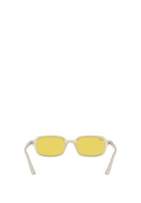 Gafas de sol transparentes con lentes amarillos, forma rectangular y brazos delgados. Las características notables incluyen un sutil logo en la lente.