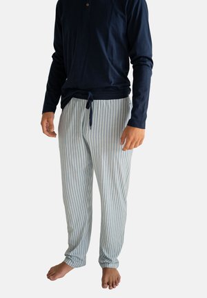 Navy blauwe blouse met lange mouwen en knopen, gecombineerd met lichtblauwe en witte gestreepte pyjamabroek. De stof lijkt zacht met een elastische tailleband.