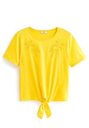 T-shirt jaune à manches courtes avec un col rond, brodé de palmiers sur le devant et un détail noué à l'ourlet.