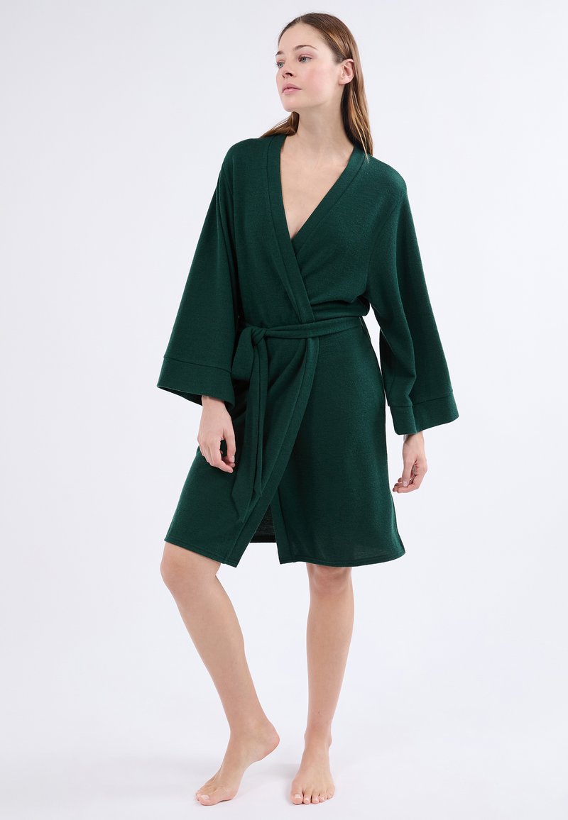 Tmavě zelený kimono-stylizovaný župan s širokými rukávy, zavazováním vpředu a opaskem. Měkká, texturovaná látka s délkou do poloviny stehna.