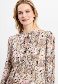 Bluse mit floralem Muster und Schlüsselloch-Ausschnitt, mit Plissee-Details und langen Ärmeln. Verfügt über ein mehrfarbiges Muster in Rosa, Grün und Creme.
