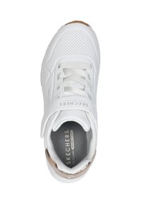 Weißer Sneaker mit perforiertem Obermaterial, Schnürverschluss und einem Klettverschluss. Features einen braunen Akzent an der Sohle und eine graue Einlegesohle mit Branding.