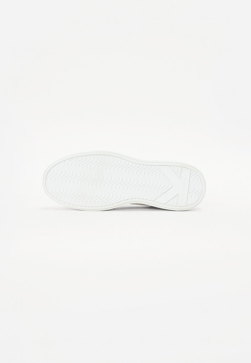 Semelle de sneaker blanche avec un motif de relief ondulé, en matériau caoutchouc et un design plat. Présente un logo et une légère élévation de talon.
