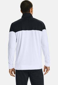 T-shirt i lång ärm för träning i vitt och svart, med hög krage och kontrasterande färgblockdesign på axlarna och ryggen.