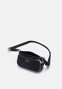 Borsa a tracolla nera in nylon con due scomparti con cerniera, dotata di una base piatta e di una tracolla regolabile con dettagli in metallo.