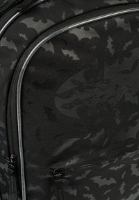 Czarny plecak z wzorem batów, z teksturowanej tkaniny, z zamkami błyskawicznymi i kontrastującymi srebrnymi wykończeniami. Dyskretne elementy w połysku.