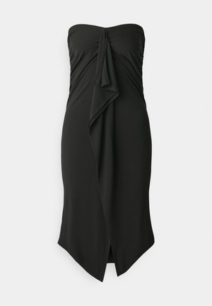 Crna haljina bez naramenica s dizajnom uvrtnog prednjeg dijela, koja ima ravnu siluetu i asimetričnu nižu stranu. Izrađena od glatkog materijala.