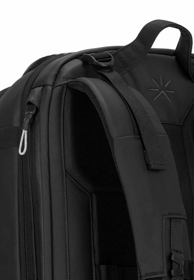 Zaino nero con un esterno resistente, dotato di un compartimento con cerniera, spallacci imbottiti e una superficie texturizzata per una migliore presa.