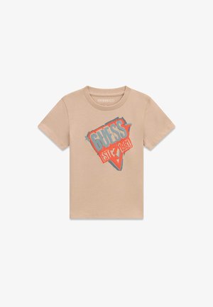 Beige T-shirt met korte mouwen met een kleurrijk GUESS-logo en "EST 1981" gedrukt in het midden vooraan.