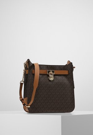 Brązowa torebka Michael Kors na ramię z złotą blokadą z logo, regulowanym paskiem z brązowej skóry i wzorem z monogramem MK.