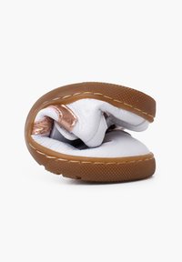 Bílé kožené boty s flexibilním designem, vybavené hnědou textura podešví a růžově zlatým kovovým akcentem. Zakřivený profil, kompaktní tvar.