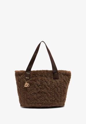Borsa a mano in finta pelliccia marrone con un design a maglia cable texturizzata, manici in pelle e un charm in metallo dorato con il logo del brand.
