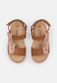 Brown leather sandals featuring dual straps and a decorative butterfly accent in soft pink with glitter. Smooth insole, lightweight design.