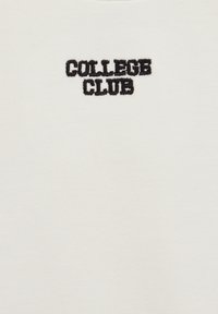 Tejido blanco con texto bordado en negro que dice "COLLEGE CLUB." La tela es suave y tiene una textura lisa y sencilla.